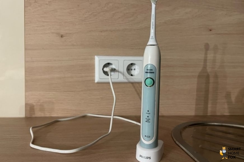 Charging the electric toothbrush with the mains plug.